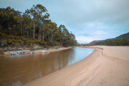 Freshwater channel runs through a beach before flowing into the Cantabrian Sea in Espasante Galiciaの写真素材
