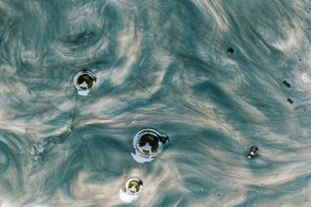 Abstract background of flow waves and bubbles in the silt of a puddle in Lugo Galicia