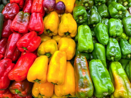 Green, yellow and red peppers in the supermarketの写真素材