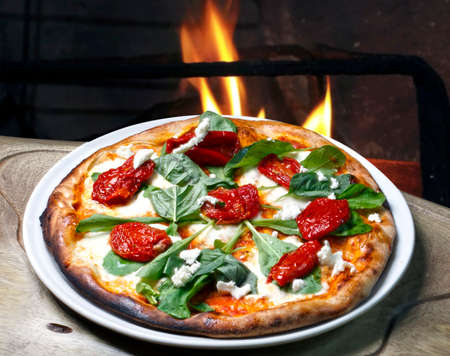 Pizza with arugula and sun dried tomatoesの写真素材