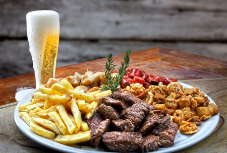 Plate of snacks, meat, potatoes, sausage, cracklings and beerの写真素材