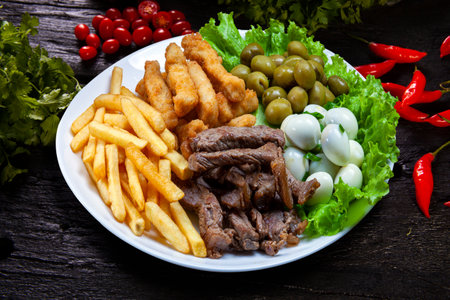 Snacks with fries, meat Picanha, quail egg, olives and breaded fish, brazilian snackの写真素材