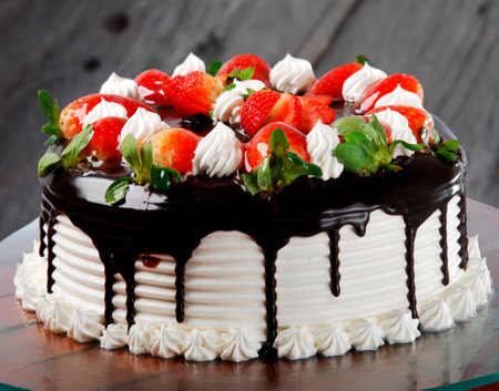 Cake with white chocolate icing, whipped cream and strawberriesの写真素材