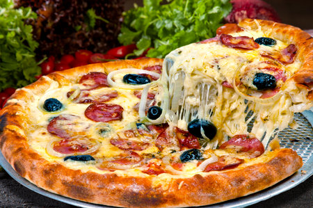 Pepperoni pizza with slices of onions baked in a wood ovenの写真素材