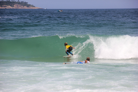 Surfing boy at Arpoador Beach, located near Ipanema, in the city of Rio de Janeiro, Brazil.の写真素材