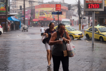 After a very hot day, with temperatures rising from 35 degrees Celsius, heavy rain hit some  Iparts of the city of Rio de Janeiro. With the rain, the streets of the neighborhood were partially flooded and many people ended up wet with the unexpected rain のeditorial素材