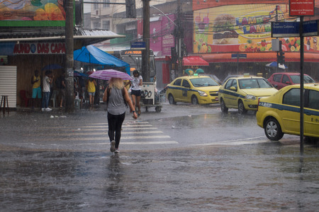 After a very hot day, with temperatures rising from 35 degrees Celsius, heavy rain hit some parts of the city of Rio de Janeiro.  With the rain, the streets of the neighborhood were partially flooded and many people ended up wet with the unexpected rain iのeditorial素材