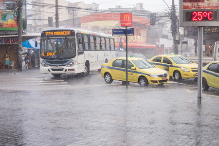After a very hot day, with temperatures rising from 35 degrees Celsius, heavy rain hit some parts of the city of Rio de Janeiro. With the rain, the streets of the neighborhood were partially flooded and many people ended up wet with the unexpected rain inのeditorial素材