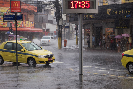 After a very hot day, with temperatures rising from 35 degrees Celsius, heavy rain hit some parts of the city of Rio de Janeiro. With the rain, the streets of the neighborhood were partially flooded and many people ended up wet with the unexpected rain inのeditorial素材