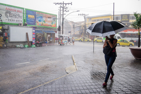 After a very hot day, with temperatures rising from 35 degrees Celsius, heavy rain hit some parts of the city of Rio de Janeiro. With the rain, the streets of the neighborhood were partially flooded and many people ended up wet with the unexpected rain inのeditorial素材