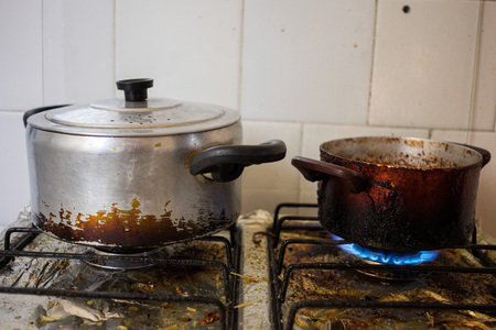 Dirty pans on filthy stove representing unhealthy eating habits with frying.の写真素材