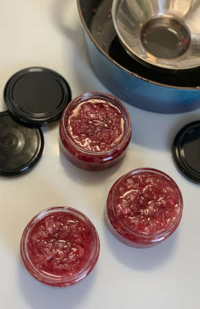 Homemade jam with roses on a white table