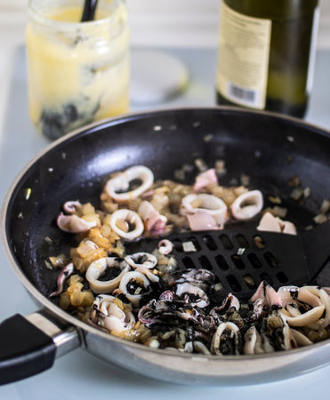 Italian pasta with baby squid and cuttlefish ink, cooking process