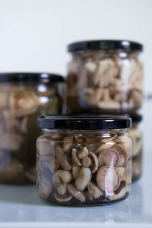 Glass jar of preserved many mushroomの写真素材