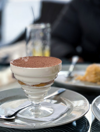 A serving of tiramisu is presented on a plate atop a table, showcasing the delicious dessert made with layers of coffeesoaked sponge cake and creamy mascarpone cheeseの写真素材