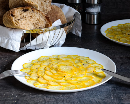 A bowl of Sptzle, a staple food in German cuisine, sits next to a plate of hearty soup. The bread complements the dish perfectly on the tableの写真素材