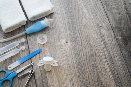 Baby care products nose cleaning cloths scissors pacifier nail file on wood backround top down flat lay with copy space negative space.の写真素材