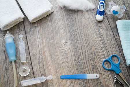 Baby care products nose cleaning cloths scissors pacifier nail file on wood backround top down flat lay with copy space negative space.の写真素材
