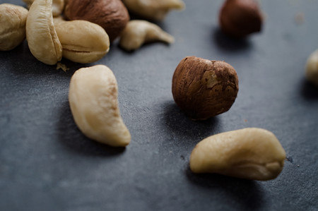 Mixed Cashew and hazel nuts on dark background. Selective focus.の写真素材