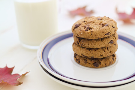 Milk and cookies in stack with seasonal decoration fall leaves