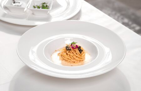 Spaghetti al Caviale (Spaghetti with Caviar), served in a white plate on a restaurant table.の写真素材