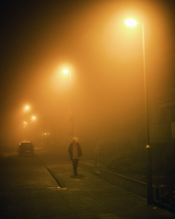 2021 04 03, Duisburg, Germany: A woman walking through thick fog at nightのeditorial素材