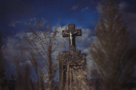 Scary leaning cross tomb stones in a foggy dark winter scene. Old creepy Christian grave on cemetery in Europe. Halloween wallpaper. Rest in peace. Spooky aged tombstone on grave yard with treesの写真素材