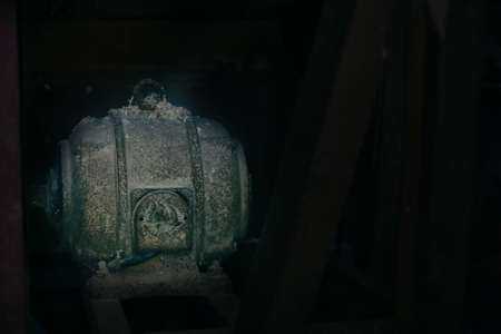 Old electric motor powering a table saw (bench saw). Vintage industrial equipment concept. Rusty and dirty electric engine power rotating machineの写真素材