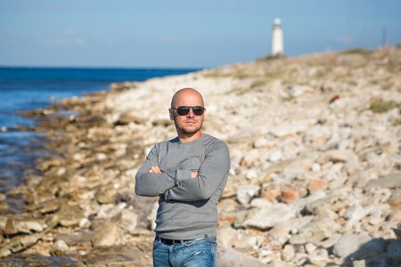 Man on a beach close to lighter beacon looking forward