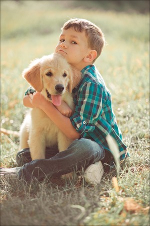 Cute handsome boy teen with blue eyes playing outdoor amazing white pink labrador retriever puppy enjoying summer sunny day vacation weekend with full happyness.Happy smiling kid with best friendの写真素材