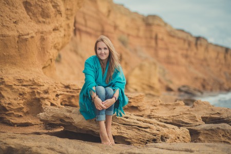 Adorable beauty lady woman eve walking posing alone on beach sea side ocean vacation wearing modish blue jeans shirt and huge hat with touchy landscape of sand cliff cape.の写真素材
