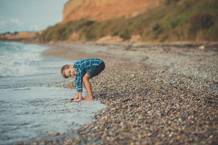 Portrait of happy boy standing alone at beach.の写真素材