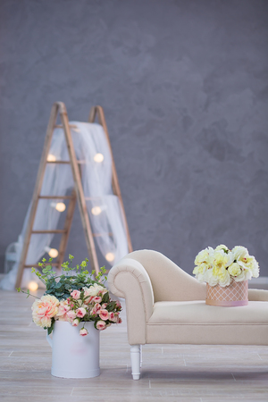 Interior mock up photo. Blue wall with leather material divan sofa and pot with plant flowers and ladder. Background photo with copy space for textの写真素材