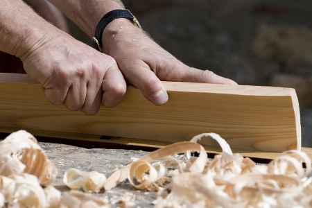 Close-up of carpenter s hands with bench plane at workの写真素材