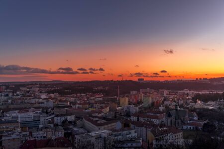 Day to night time-lapse when Brno city square and surroved area goes from sunset when sunshine change city colors to orange through sunset to night when city light goes on captured 4k high resolutionの写真素材