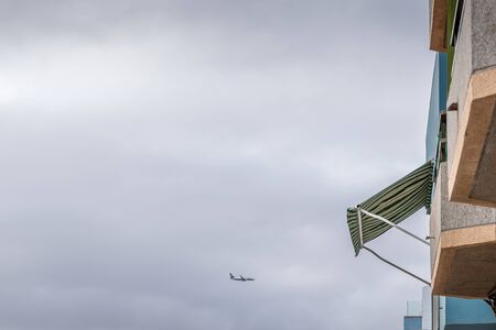 Aircraft captured during a descent to an airport while landing between two buildings from a distance...