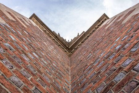 View from bottom to top on church wall in WrocÅaw with skyの写真素材