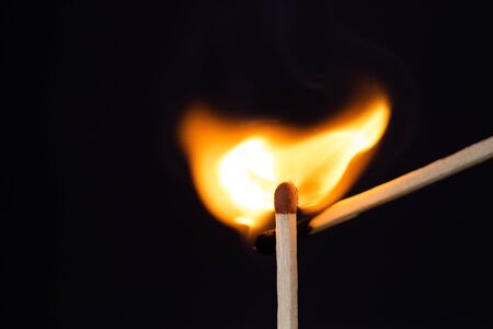 Close up Macro shot of a ignition match on a second match captured in super slow motion