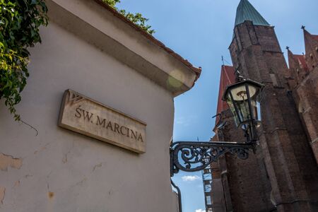 City Wroclav street sign table with lamp and church behindの写真素材