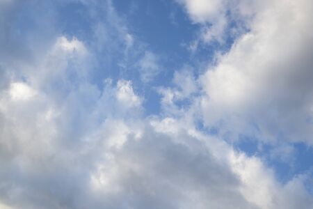 Fast moving clouds during a sunny day in the blue sky with the transition to evening hours along...