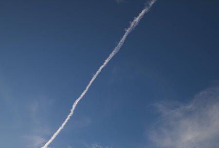 Fast moving clouds during a sunny day in the blue sky with the transition to evening hours along...