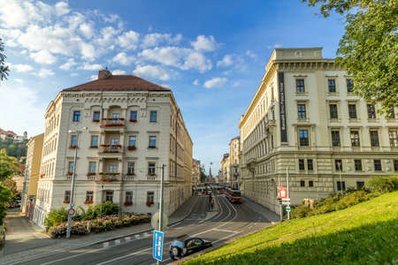 Busy street with people, cars and public transport rush street in Brno Silingrovo namesti square in Czech Republic Europe capture in close shot between buildings.のeditorial素材