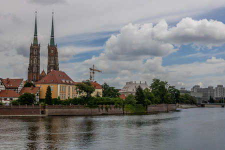 River in city WrocÅaw with big cloud coverage and curch on left sideのeditorial素材