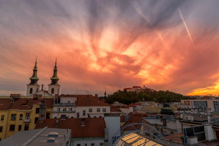 Castle Spilberk Brno Europe, Czech city, moving colored orange and blue clouds and sky with view on the area around the castle and church day to night capture.のeditorial素材