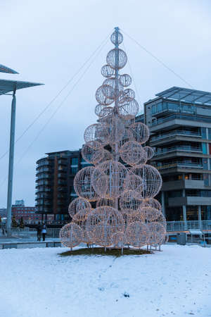 Modern architecture of the city of Oslo Norway during the winter with Christmas decoration in the snow-covered center.のeditorial素材