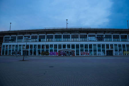 Abadoned Stadion Za LuÅ¾Ã¡nkami is a currently inactive stadium in Brno, Czech Republic. Captured in spring sunset, sky and clouds was colored to blue dark colors. Photo from tribunes and inside middle of field.のeditorial素材