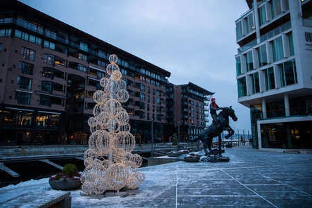 Modern architecture of the city of Oslo Norway during the winter with Christmas decoration in the snow-covered center.のeditorial素材