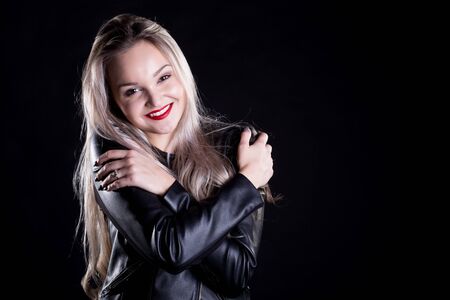 Close up studio portrait of a pretty blonde woman, smiling with red lips and looking at the camera, against plain studio backgroundの写真素材