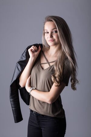 Close up studio portrait of a pretty blonde woman, smiling and looking at the camera, against plain studio backgroundの写真素材