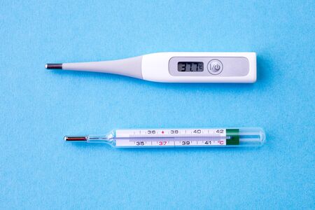 comaprison of digital and analog thermometer on blue background, covid, coronavirus